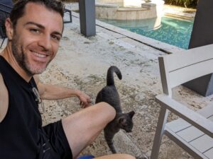 Petting a cat by the pool